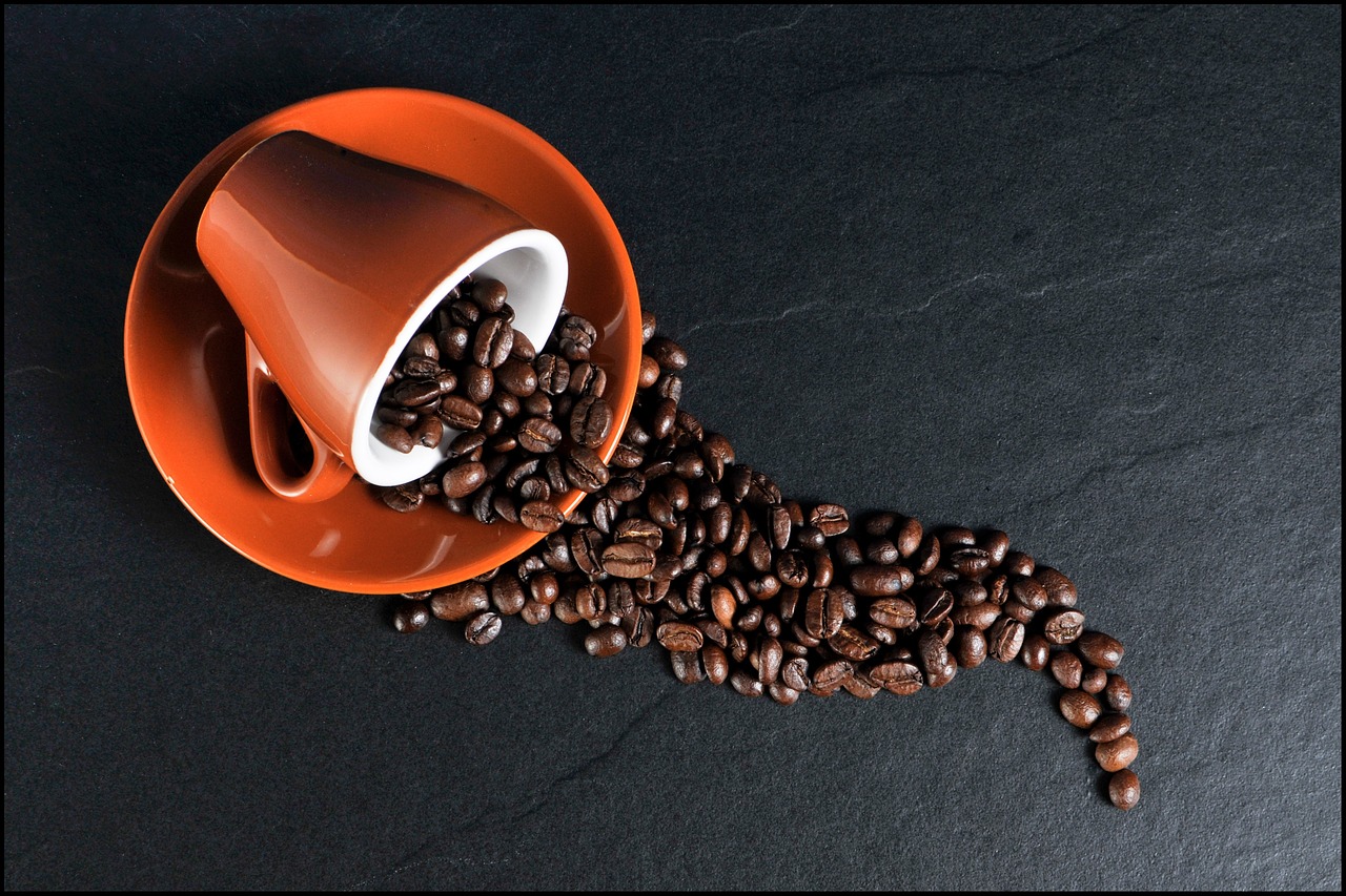 A coffee mug full of beans spille over